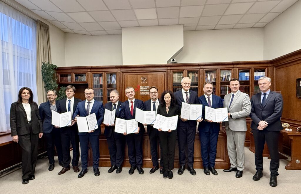 uczestnicy porozumienia trzymający w ręku podpisane porozumienia